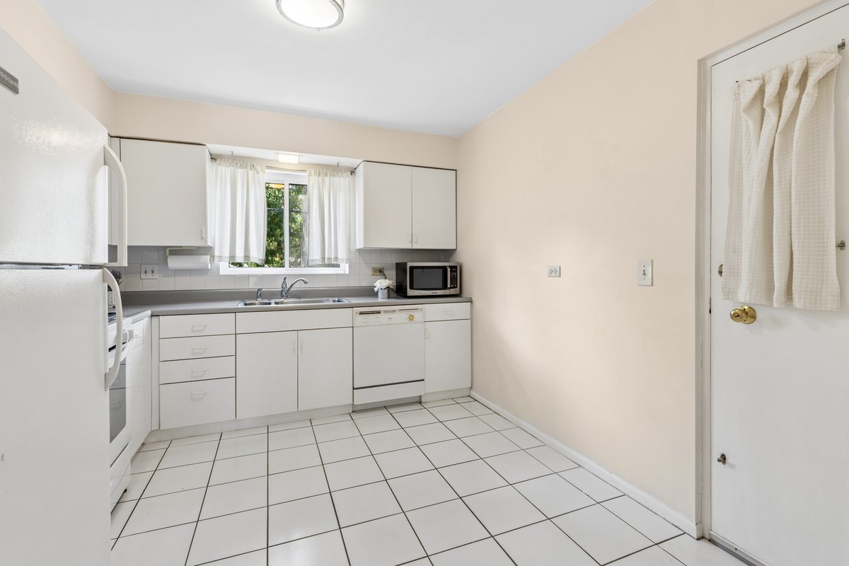 140 Green Bay Road, Unit 2 Glencoe, IL 60022 - Photo 7 of 28 a kitchen with white cabinets a sink a window and appliances