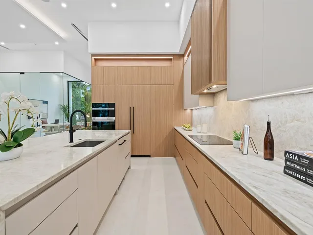 a large kitchen with granite countertop a sink and a stove top oven