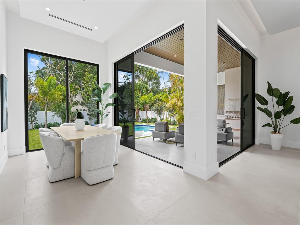 1717 Northeast 17th Terrace Fort Lauderdale, FL 33305 - Photo 19 of 40 a living room with large windows and a table