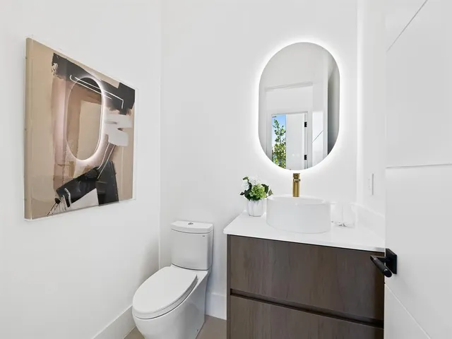 a bathroom with a toilet a sink and mirror