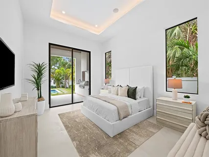 a bedroom with a large bed and a flat tv screen on dresser