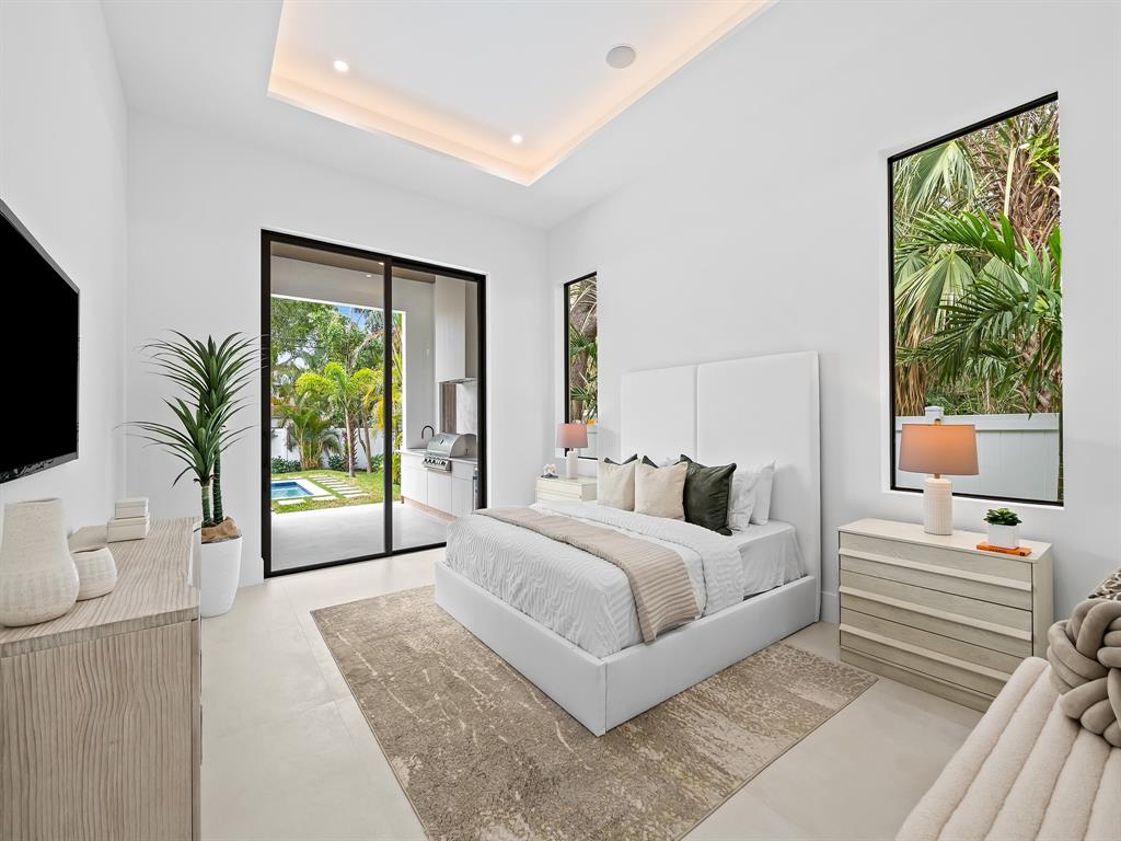 1717 Northeast 17th Terrace Fort Lauderdale, FL 33305 - Photo 21 of 40 a bedroom with a large bed and a flat tv screen on dresser