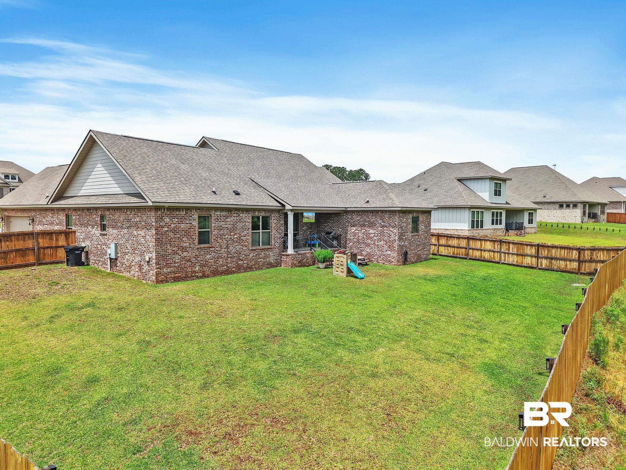 13233 Ibis Boulevard Daphne, AL 36527 - Photo 61 of 100 Expansive green lawn surrounds the rear of the property, enclosed by a wood privacy fence