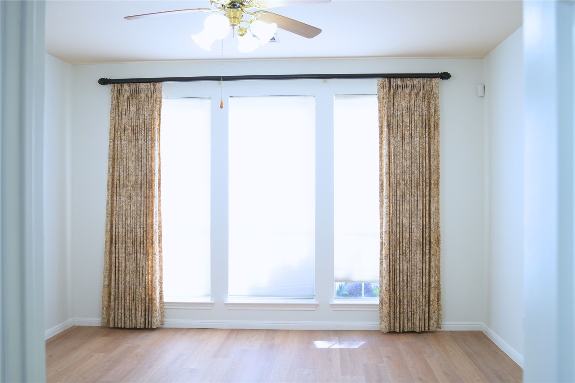 9501 Aire Libre Drive Austin, TX 78726 - Photo 17 of 38 an empty room with wooden floor and windows