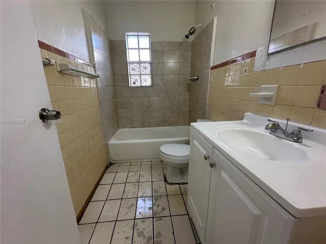 a bathroom with a sink a toilet a window and shower