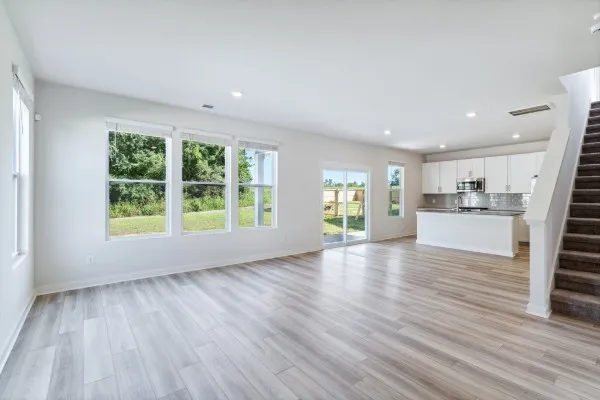a view of empty room with wooden floor and window