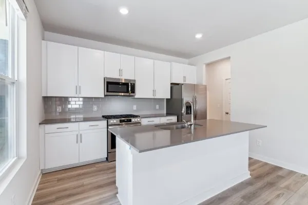 a kitchen with stainless steel appliances granite countertop a stove a sink and a refrigerator