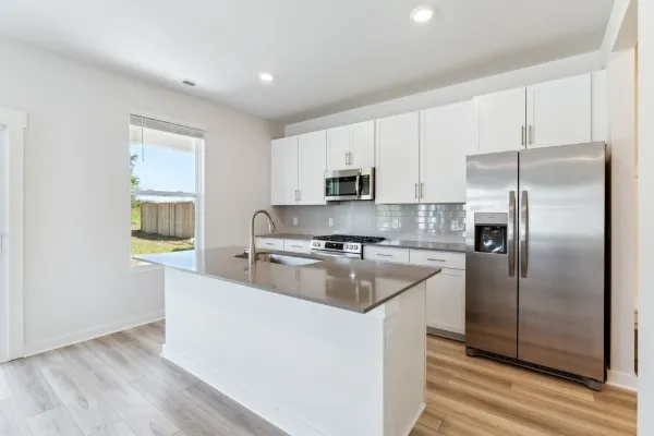 a kitchen with kitchen island a counter top space cabinets and stainless steel appliances
