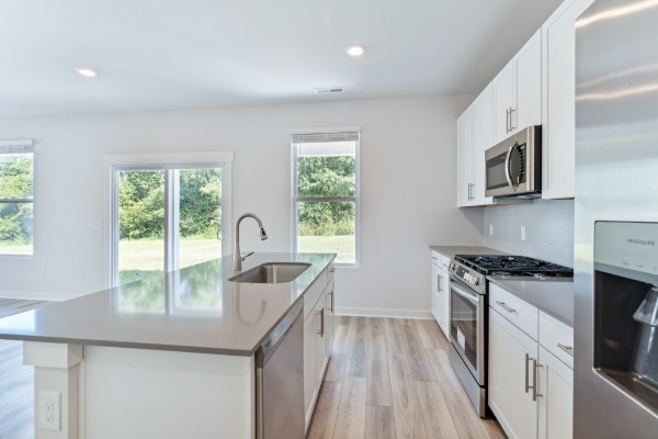 1037 Ewell Farm Drive Spring Hill, TN 37174 - Photo 10 of 31 a kitchen with granite countertop a stove a sink and a microwave