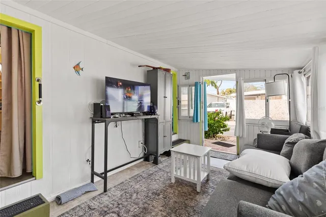 a living room with furniture a window and a flat screen tv