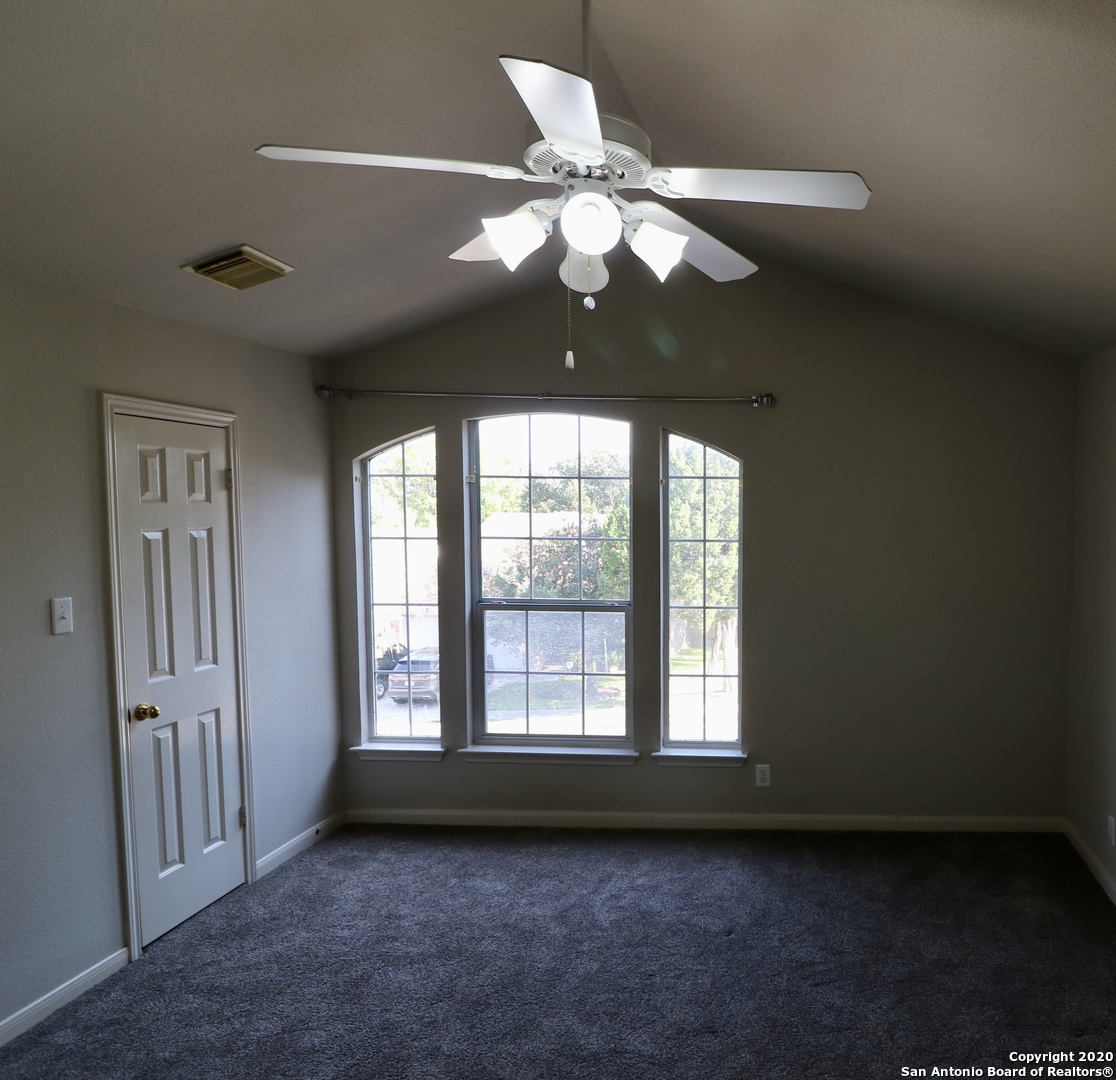 7 Claybrook San Antonio, TX 78254 - Photo 12 of 21 a view of an empty room with a chandelier fan and a large window
