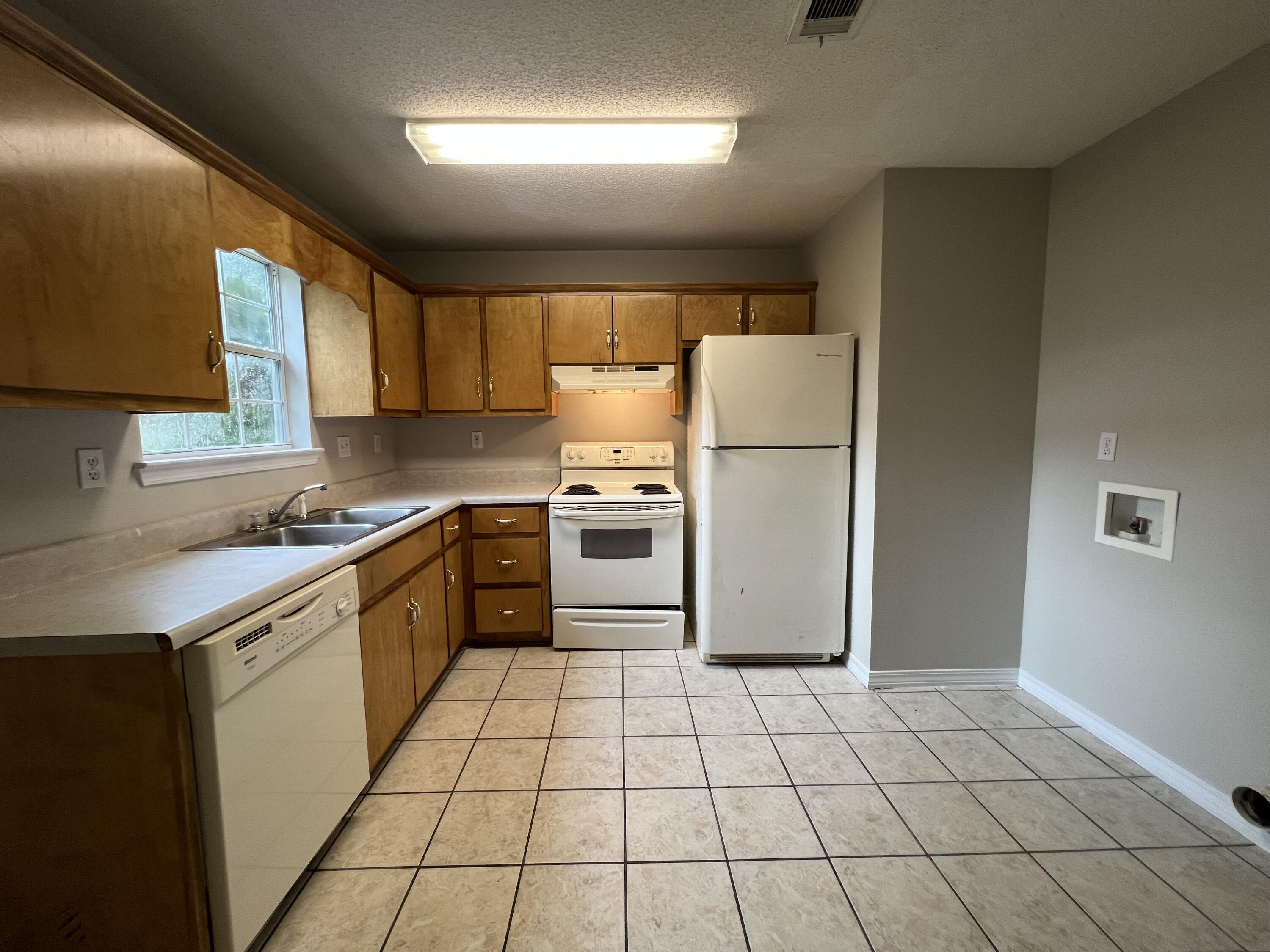 232 Runnymeade Drive Crestview, FL 32539 - Photo 11 of 11 a kitchen with a refrigerator a stove a sink cabinets and a counter top space