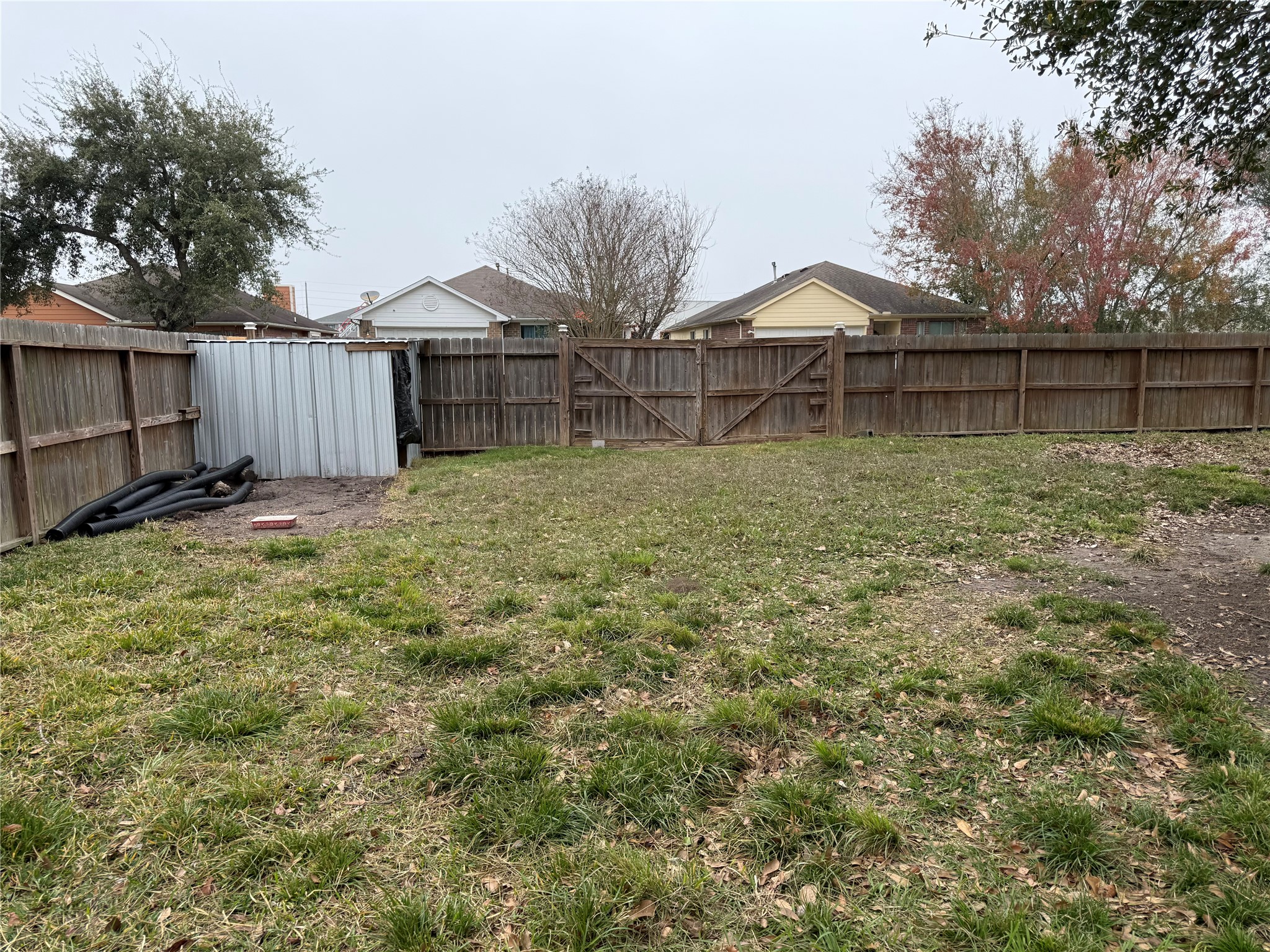 3003 Vega Houston, TX 77088 - Photo 5 of 13 a backyard of a house with large trees and wooden fence