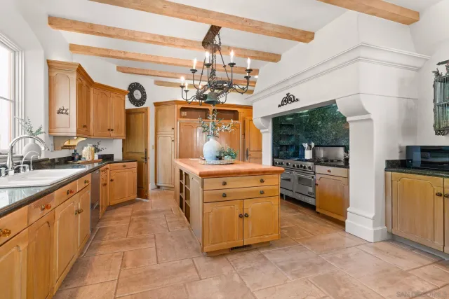 a large kitchen with kitchen island a large counter space a sink a window and stainless steel appliances