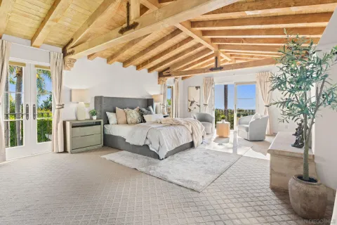 a bedroom with a large bed and a chandelier