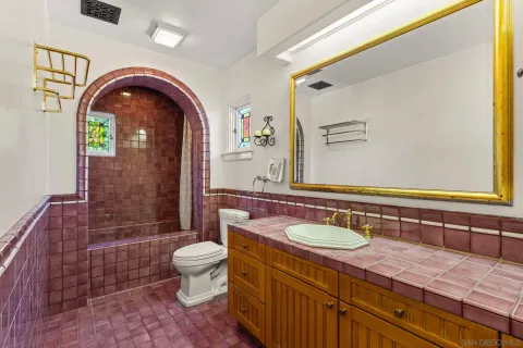 a bathroom with a granite countertop toilet a sink and a mirror