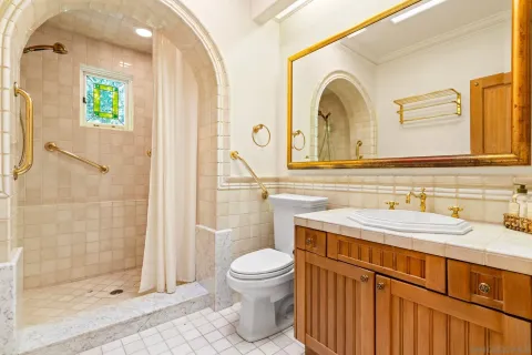 a bathroom with a granite countertop sink a toilet and a shower