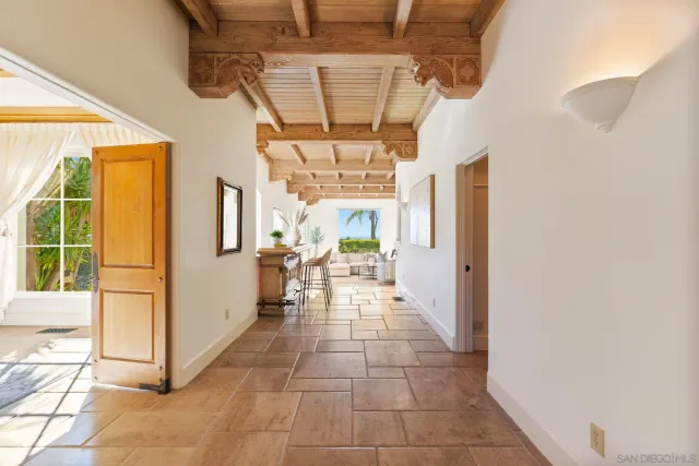 a hallway with a chandelier and a rug