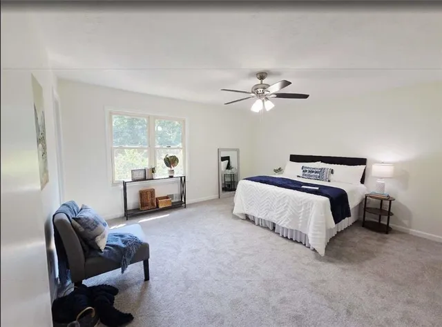 a spacious bedroom with a bed and a chandelier