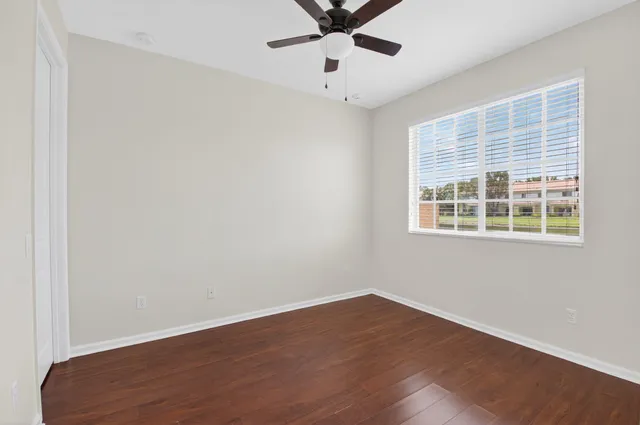 a view of a big room with wooden floor and windows