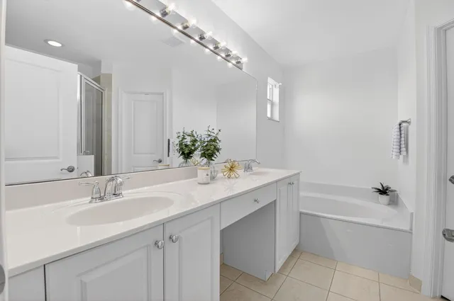 a bathroom with a sink double vanity granite tub and a mirror