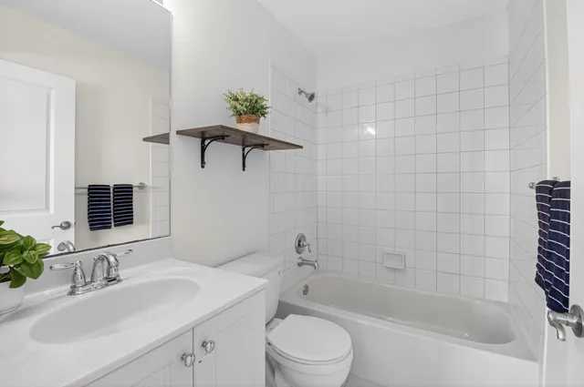 a bathroom with a bathtub shower sink vanity and toilet