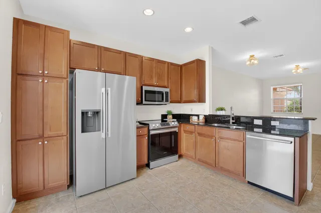 a kitchen with stainless steel appliances granite countertop a refrigerator stove and sink