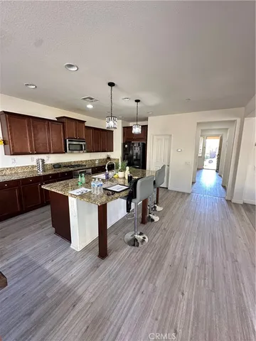a living room with stainless steel appliances kitchen island granite countertop wooden floors and view living room