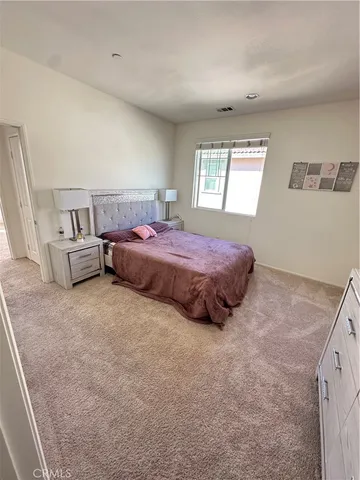 a spacious bedroom with a bed and window