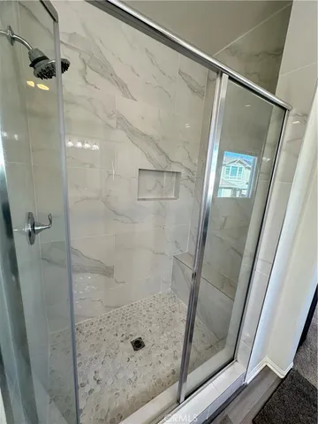 a bathroom with a glass shower door and mirror