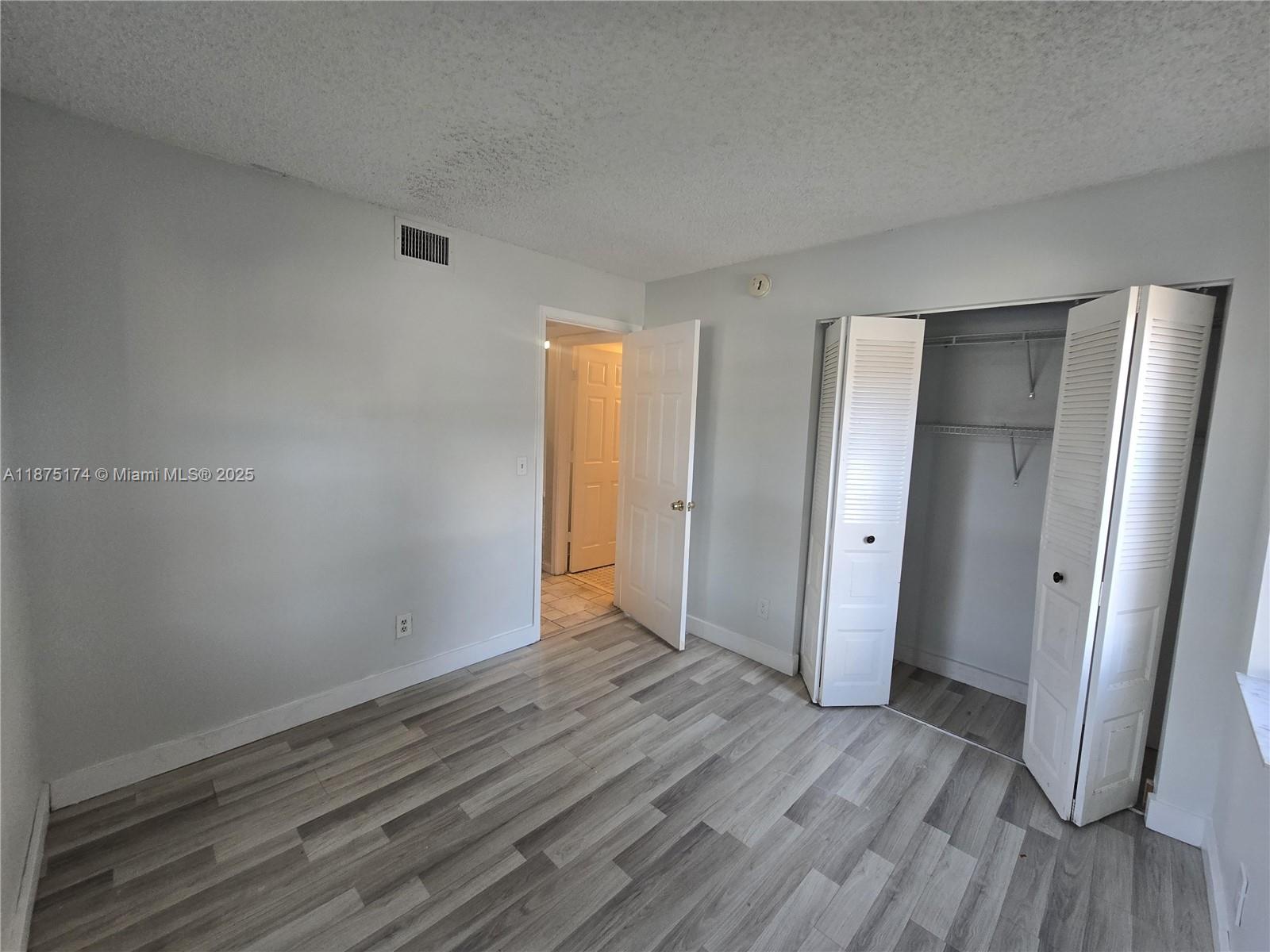 10600 Northwest 10th Street, Unit 106 Pembroke Pines, FL 33026 - Photo 13 of 17 a view of an empty room with wooden floor and closet