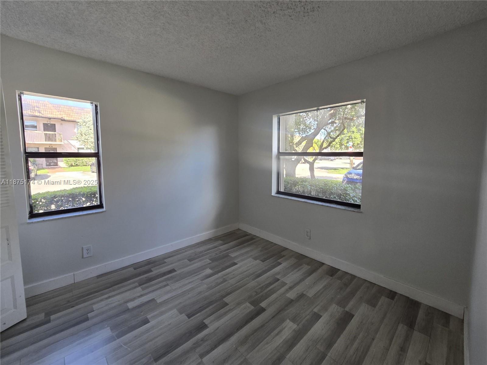 10600 Northwest 10th Street, Unit 106 Pembroke Pines, FL 33026 - Photo 15 of 17 a view of an empty room with wooden floor and a window