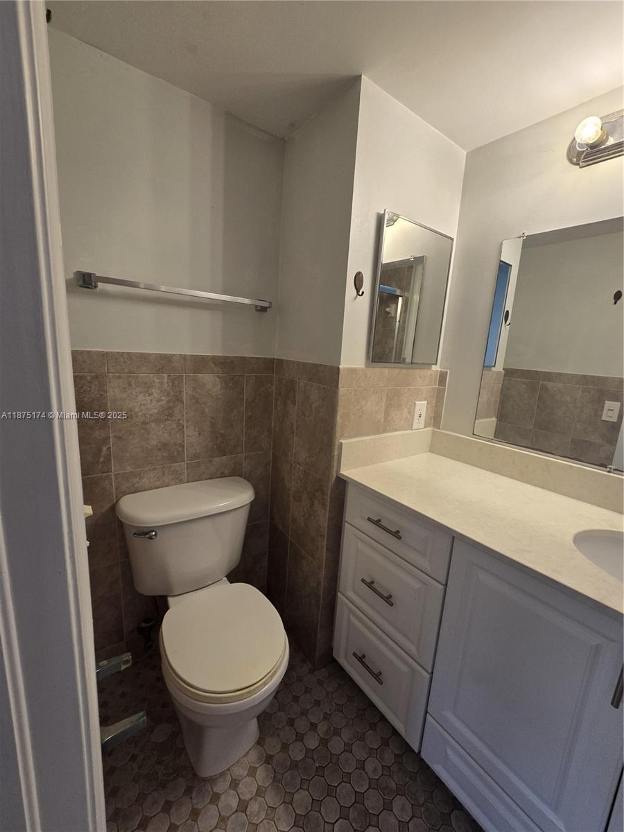 10600 Northwest 10th Street, Unit 106 Pembroke Pines, FL 33026 - Photo 16 of 17 a bathroom with a toilet a sink and mirror