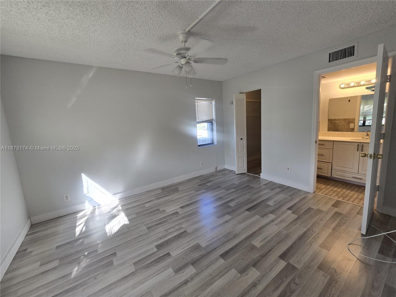 10600 Northwest 10th Street, Unit 106 Pembroke Pines, FL 33026 - Photo 10 of 17 a view of empty room with wooden floor and fan
