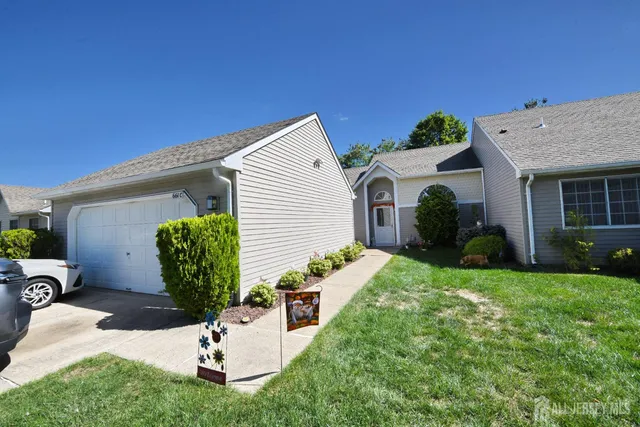 a view of a house with a yard and potted plants