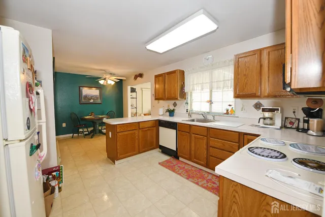 a large living room with stainless steel appliances kitchen island granite countertop furniture and a large window