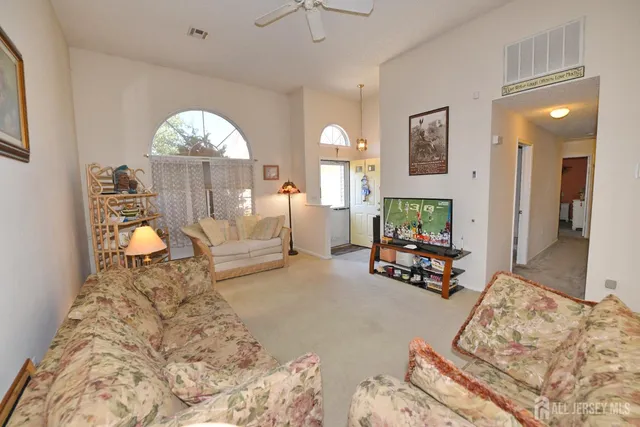 a living room with furniture a lamp and a flat screen tv
