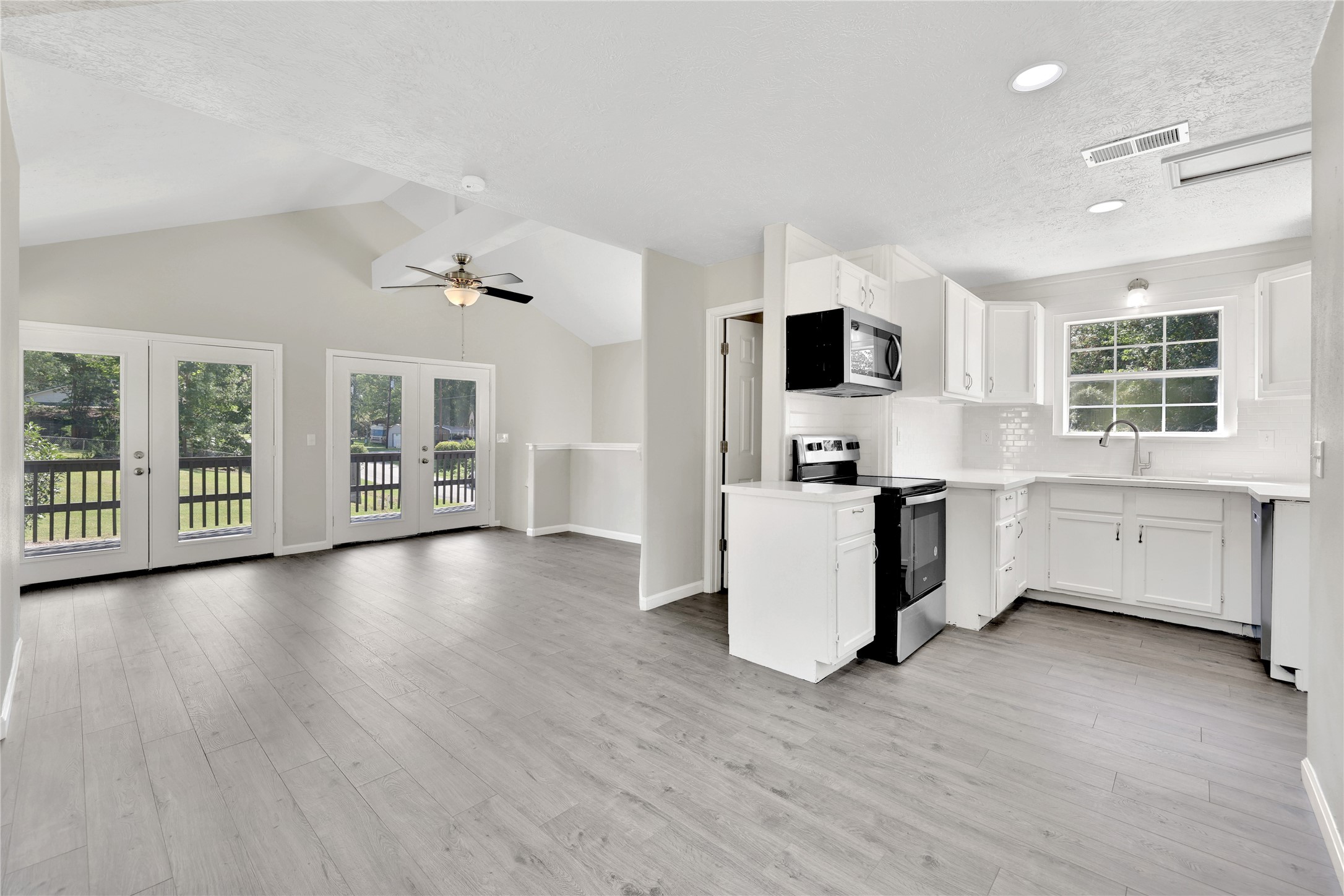 31 Montego Way Point Blank, TX 77364 - Photo 10 of 23 a kitchen with stainless steel appliances a stove top oven a sink a refrigerator white cabinets and wooden floor