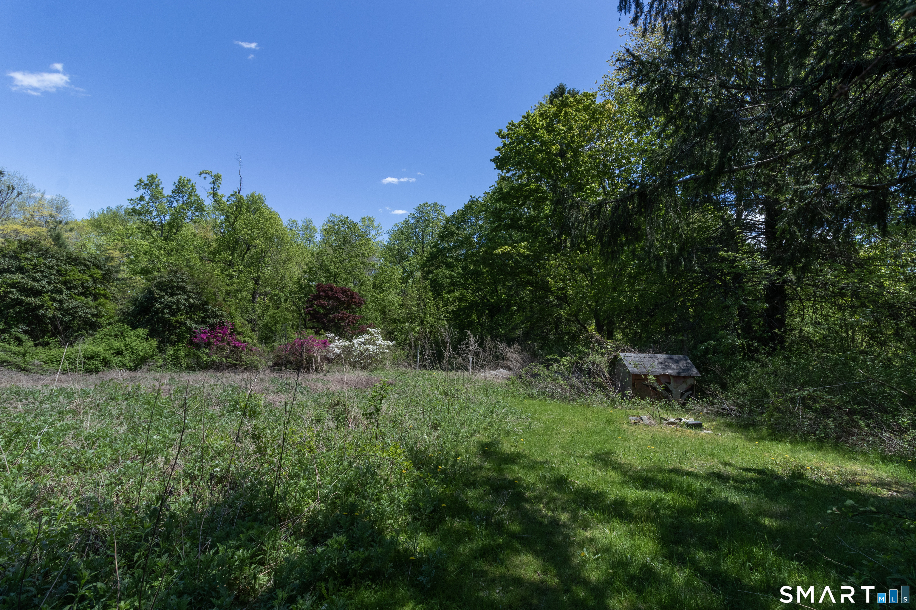 1973 Long Hill Road Guilford, CT 06437 - Photo 13 of 19 a backyard of a house with table and chairs in it