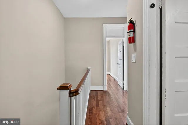 a view of a hallway with wooden floor and staircase