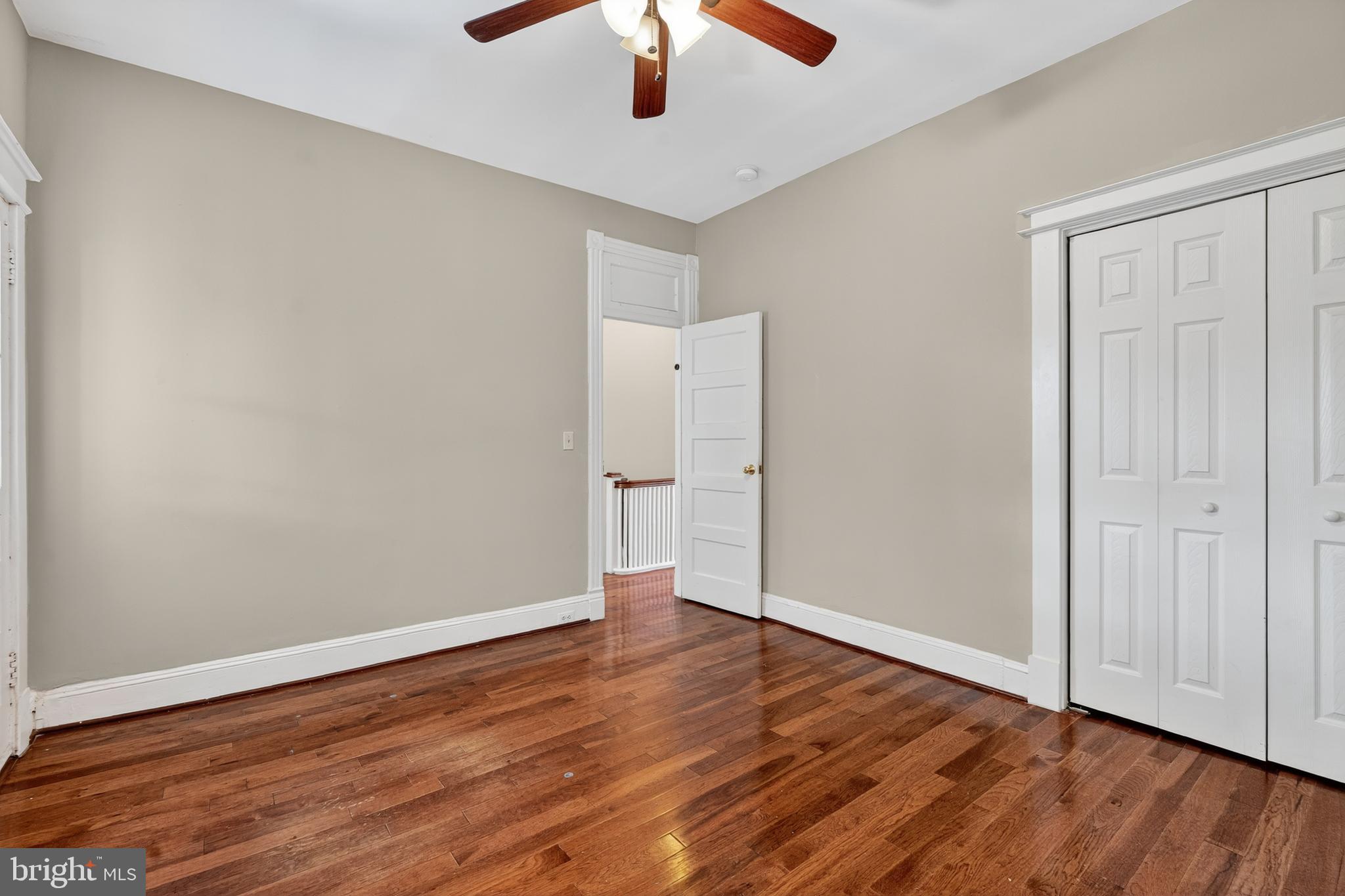 3523 Warder Street Northwest Washington, DC 20010 - Photo 13 of 30 an empty room with wooden floor chandelier fan and windows