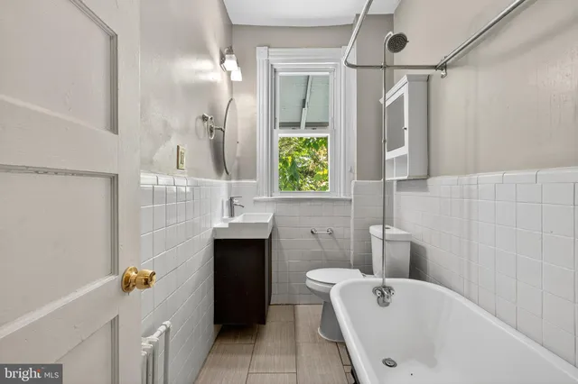 a bathroom with a tub sink and mirror