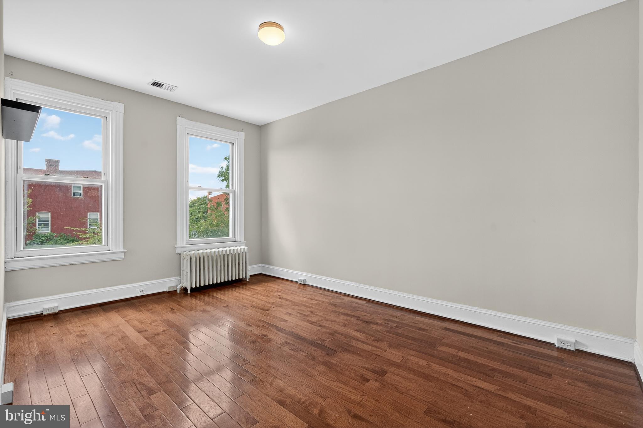 3523 Warder Street Northwest Washington, DC 20010 - Photo 17 of 30 an empty room with wooden floor and windows