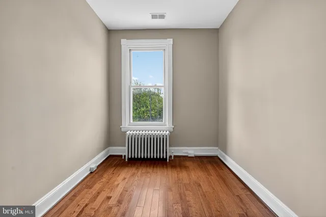 a view of a room with wooden floor and window