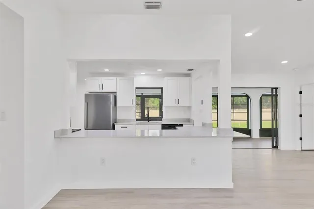 a large white kitchen with a large window