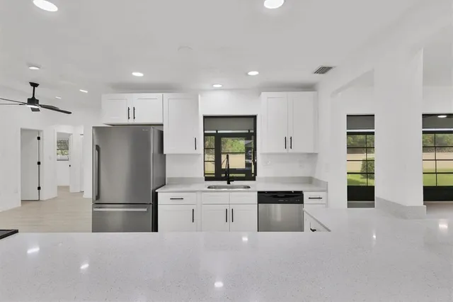 a kitchen with stainless steel appliances a refrigerator sink and stove