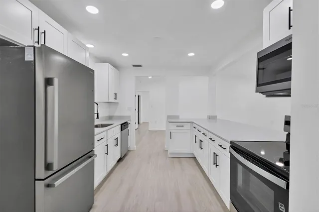 a kitchen with stainless steel appliances a refrigerator sink and stove