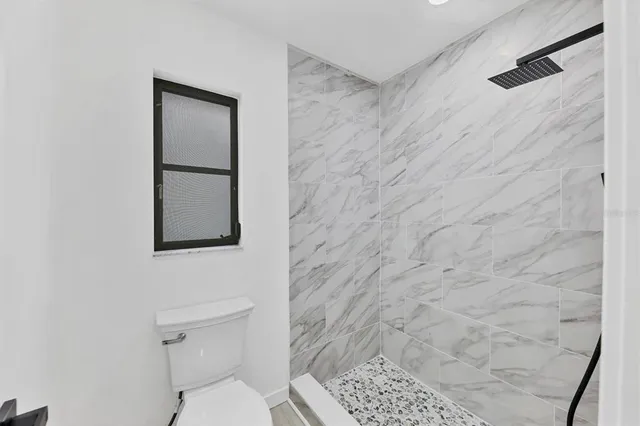 a bathroom with a toilet and a shower