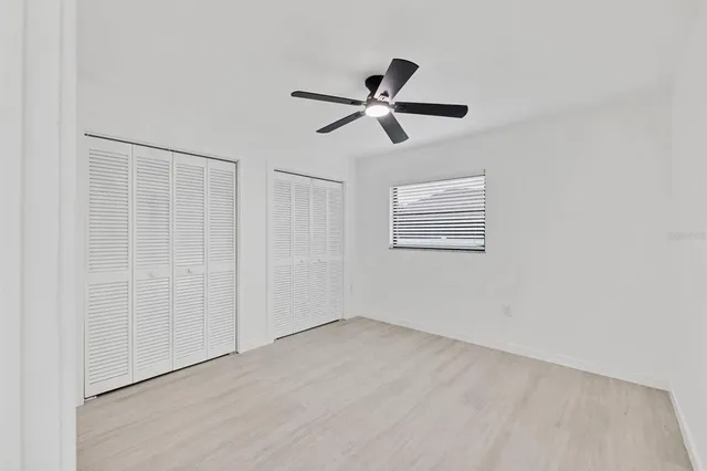 a view of a big room with wooden floor and windows