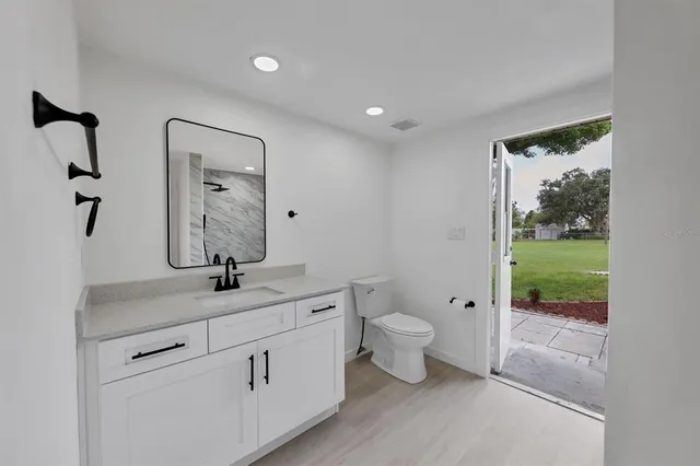 a bathroom with a granite countertop sink a toilet and a mirror